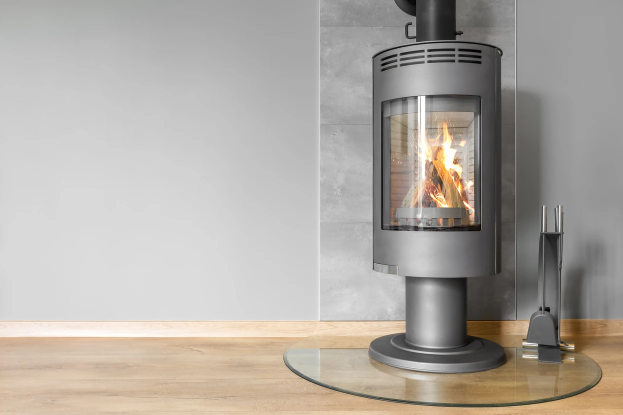 Intérieur moderne avec poêle à bois cylindrique en acier gris sur socle rond