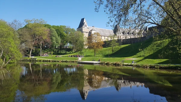 Photographie aérienne ou vue urbaine de Châteaubriant mettant en évidence le centre-ville avec ses bâtiments caractéristiques et son château, prise en lumière naturelle de jour, claire et professionnelle, sans texte ni filigrane. L'image doit transmettre une impression d'accessibilité et de proximité locale, en accord avec le message d'intervention dans la région.
