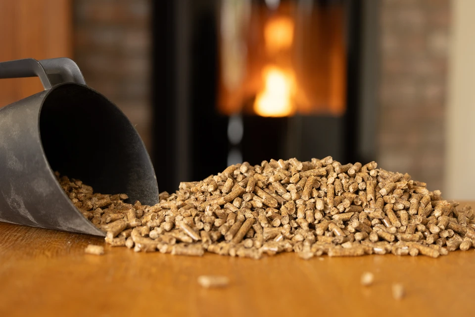 Granulés de bois cylindriques en combustion avec flammes jaunes vives