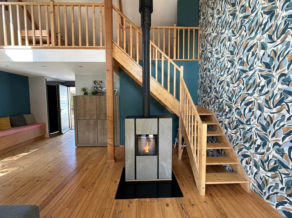 Poêle à granulés design noir mat installé dans un salon moderne, posé sur carrelage marbre blanc