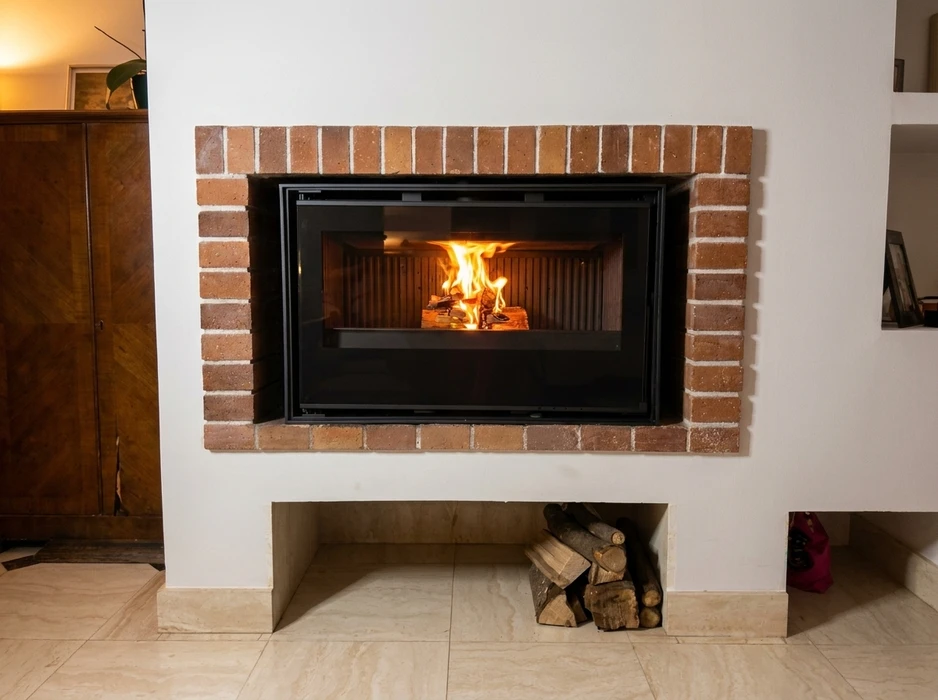 Intérieur moderne avec cheminée à foyer fermé en fonctionnement, flammes visibles à travers la vitre