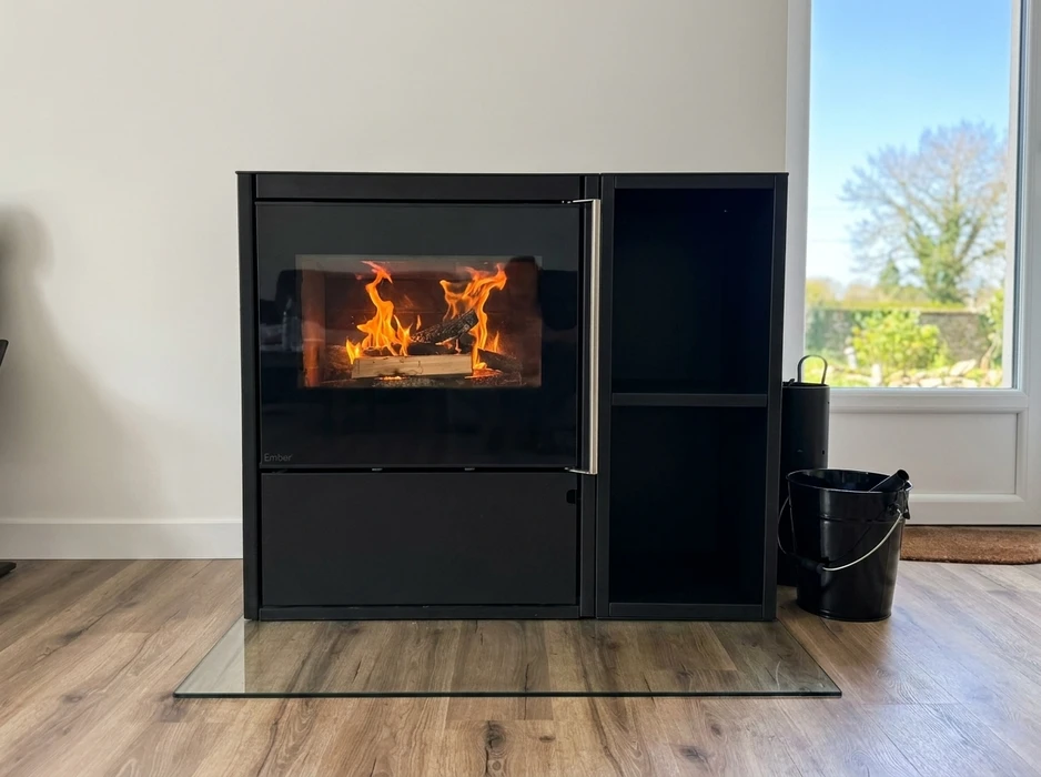 Poêle à granulés design noir mat installé dans un salon moderne, posé sur carrelage marbre blanc