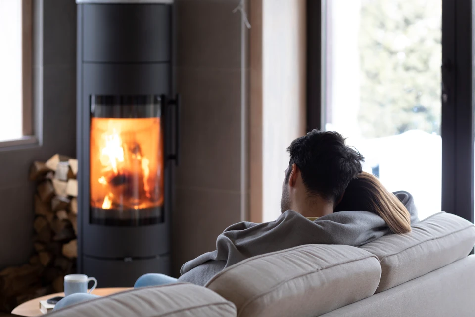 Intérieur moderne avec poêle à bois en fonctionnement, flammes visibles à travers la vitre